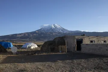 Karlı Ağrı Dağı önünde kırsal yerleşim, evler ve geniş açık arazinin doğal manzarası.