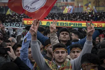 21 Mart 2025 Amed Newrozunda gençlerin zafer işaretleriyle kutlama coşkusunu yansıtan kalabalık etkinlik görüntüsü.
