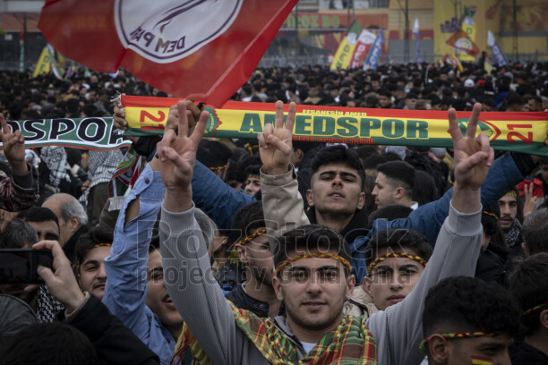 21 Mart 2025 Amed Newrozunda gençlerin zafer işaretleriyle kutlama coşkusunu yansıtan kalabalık etkinlik görüntüsü.