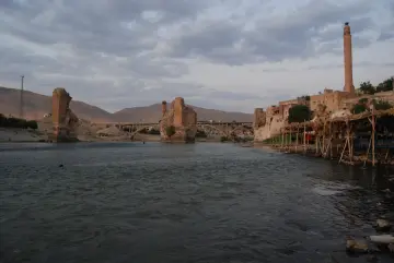 Batman Hasankeyf'te Dicle Nehri, tarihi köprü kalıntıları ve geleneksel taş yapıların manzarası.