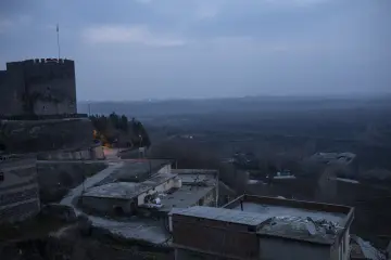 Diyarbakır İçkale ve tarihi surların Dicle Vadisi'ne uzanan akşam manzarası, puslu atmosfer ve kent dokusuyla.