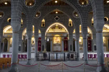 Diyarbakır Meryem Ana Süryani Kadim Kilisesi'nin bazalt sütunlar, kemerler ve ikonalarla bezeli iç mekanı.