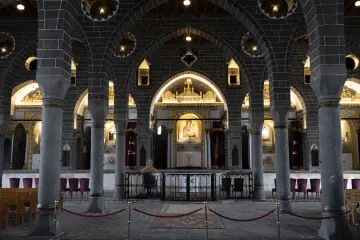 Diyarbakır Meryem Ana Süryani Kadim Kilisesi'nin siyah taş kemerler, sütunlar ve ikonalarla bezeli tarihi iç mekânı.