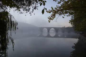 Diyarbakır On Gözlü Köprü'nün yoğun sis altında Dicle Nehri üzerindeki kemerleri ve yansıması.