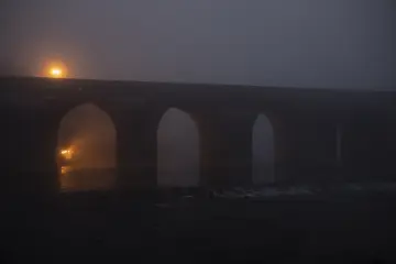 Diyarbakır On Gözlü Köprü'nün sisli havada gün batımı ve Dicle Nehri üzerindeki yansıması.
