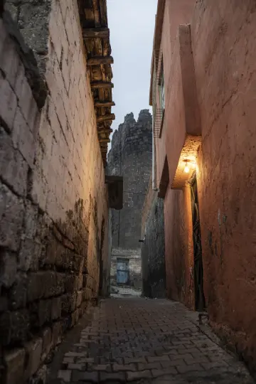 Diyarbakır Suriçi tarihi taş sokak fotoğrafı, bazalt duvarlar, dar geçit ve geleneksel şehir dokusu.