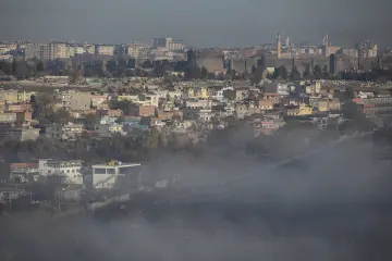 Diyarbakır Surları ve Hevsel Bahçeleri üzerinde yoğun sisle çevrili tarihi kent ve şehir silueti manzarası.