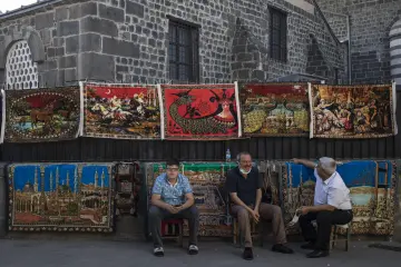 Diyarbakır tarihi çarşılarında sergilenen renkli halı ve kilimler, taş mimari ve geleneksel ticaret atmosferi.