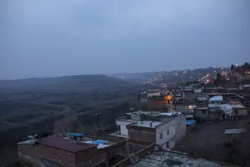 Diyarbakır Hevsel Bahçeleri ve Dicle Vadisi üzerinde akşam sisi, yamaç evleri ve şehir ışıklarıyla etkileyici manzara.