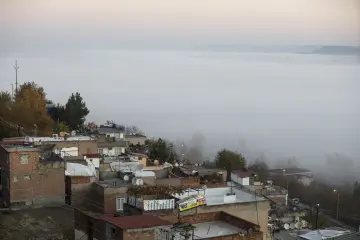 Diyarbakır'da yoğun sis altında kalan mahalle, ağaçlık alanlar ve Dicle Vadisi çevresinin puslu şehir manzarası.