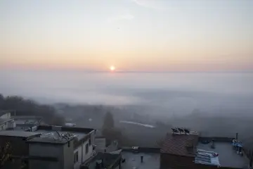 Diyarbakır Hevsel Bahçeleri ve Dicle Vadisi üzerinde sisli gün doğumu, evler ve ağaçlık alanlarla etkileyici sabah manzarası.