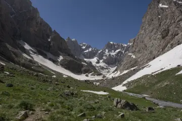 Hakkâri Cilo Dağları'nda karlı buzul vadisi, sarp kayalıklar ve eriyen kar sularıyla oluşan doğal manzara.