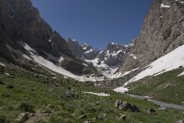 Hakkâri Cilo Dağları'nda karlı buzul vadisi, sarp kayalıklar ve eriyen kar sularıyla oluşan doğal manzara.