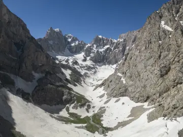 Hakkâri Cilo Dağları'nda sarp kayalık zirveler, kar örtüsü, buzullar ve eriyen kar sularıyla oluşan etkileyici dağ manzarası.