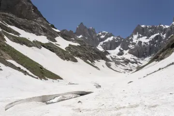 Hakkâri Cilo Dağları'nda karlı zirveler, sarp kayalıklar ve geniş kar örtüsüyle etkileyici buzul dağ manzarası.