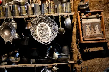 Harran konik kubbeli evinin içindeki geleneksel eşyalar ve metal kapların kültürel görünümü.