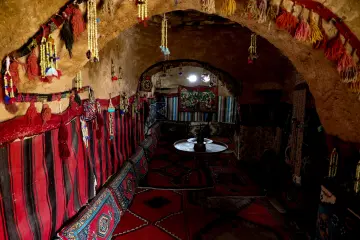 Harran kümbet evinin otantik iç mekânı, kerpiç mimarisi ve geleneksel dekorasyonunu gösteren tarihi yaşam alanı.