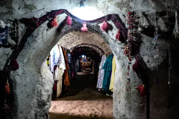 Harran Kümbet Evi'nin iç mekanında geleneksel dokumalar, süslemeler ve yöresel eşyalar.