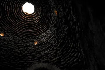 Harran Kümbet Evi'nin içindeki konik kubbe, tuğla dokusu ve üst açıklığın mimari görünümü.