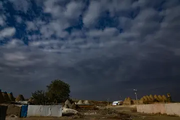 Şanlıurfa'nın Harran ilçesindeki tarihi konik kubbeli kerpiç evler, dramatik bulutlarla kaplı gökyüzü