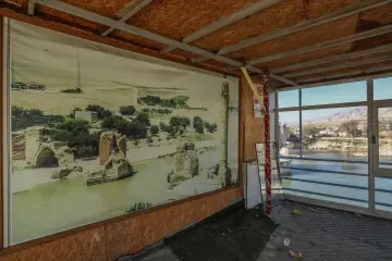 Hasankeyf'te eski bir yapının yıpranmış penceresinden dışarı bakan genç bir buzağı. Tuğla duvar, ahşap pencere ve hayvanın meraklı bakışı, tarihi çevre ile kırsal yaşamın iç içe geçtiği doğal bir sahne oluşturuyor.