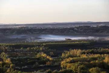 Diyarbakır Hevsel Bahçeleri'nde sonbahar renkleri, tarım alanları ve sisle kaplanan Dicle Vadisi'nin etkileyici manzarası.