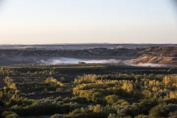 Diyarbakır Hevsel Bahçeleri'nde sonbahar renkleri, sisli Dicle Vadisi ve altın ışıkla aydınlanan doğal peyzaj.