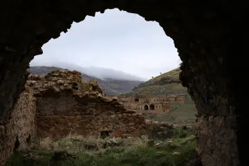 Mardin Savur Dereiçi kaya açıklığı, taş yapılar ve sisli dağ manzarası