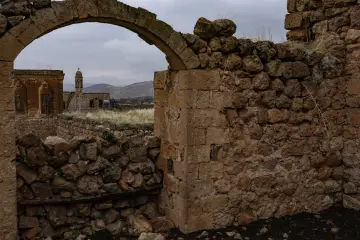Mardin Savur tarihi taş yapılar, kemerli geçit, kilise kulesi ve dağ manzarası