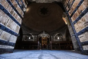 Meryem Ana Süryani Kadim Kilisesi girişinden görülen tuğla kubbe, taş kemerler ve tarihi iç mekan.