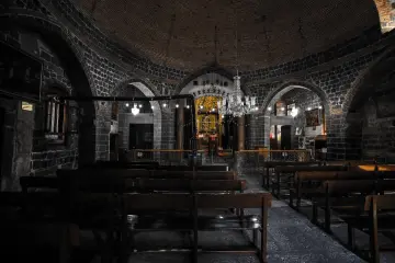 Meryem Ana Süryani Kadim Kilisesi'nin tuğla kubbeli, bazalt taş duvarlı ve kemerli tarihi iç mekanı.