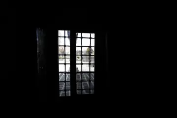 Meryem Ana Süryani Kadim Kilisesi'nin tarihi iç mekanında taş mimari ve kafesli pencerelerden süzülen ışık.