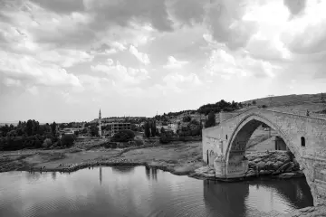 Siyah beyaz Malabadi Köprüsü fotoğrafı, dramatik bulutlar ve tarihi taş mimariyi etkileyici bir kompozisyonda sunuyor.