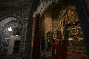 Tarihi kilise iç mekanında taş kemerler, tuğla kubbe, süslü sunak, dini tasvirler ve geleneksel mimari detaylar.
