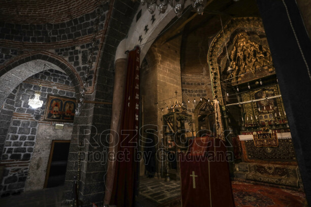 Tarihi kilise iç mekanında taş kemerler, tuğla kubbe, süslü sunak, dini tasvirler ve geleneksel mimari detaylar.