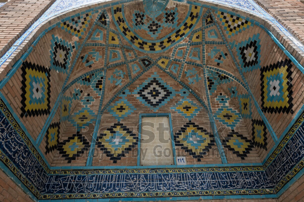 İran Yezd Ulu Camii'nde mavi çini mozaikler, geometrik motifler ve hat yazılarıyla süslü tarihi mimari detay.
