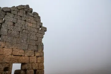 Zerzevan Kalesi'nin tarihi taş duvarı ve bulutlu gökyüzüyle öne çıkan kültürel miras manzarası.